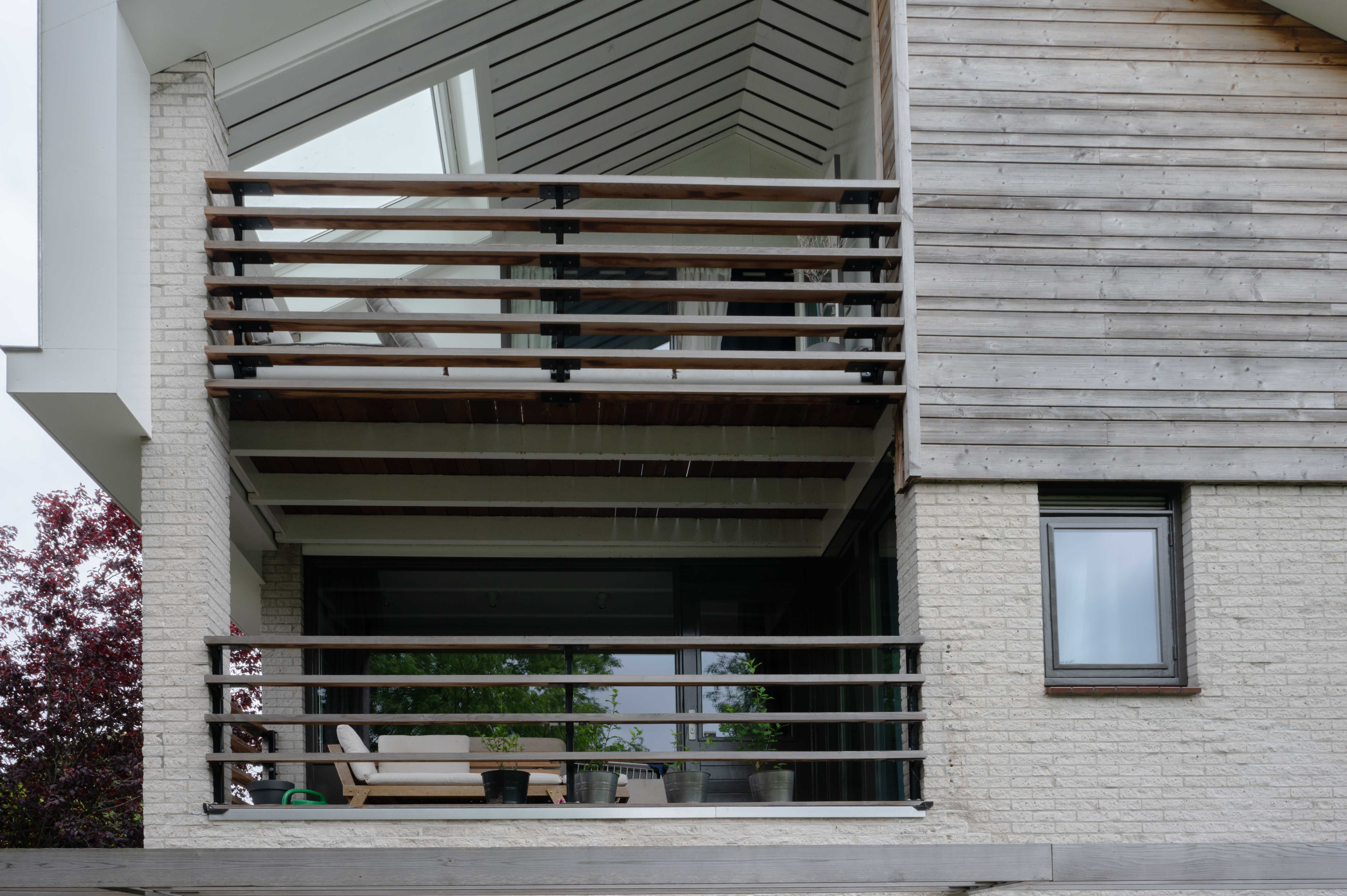 lijnenspel van balken aan de inpandige balkons van een vrijstaand huis dat door bouwbedrijf w bouw gerenoveerd is