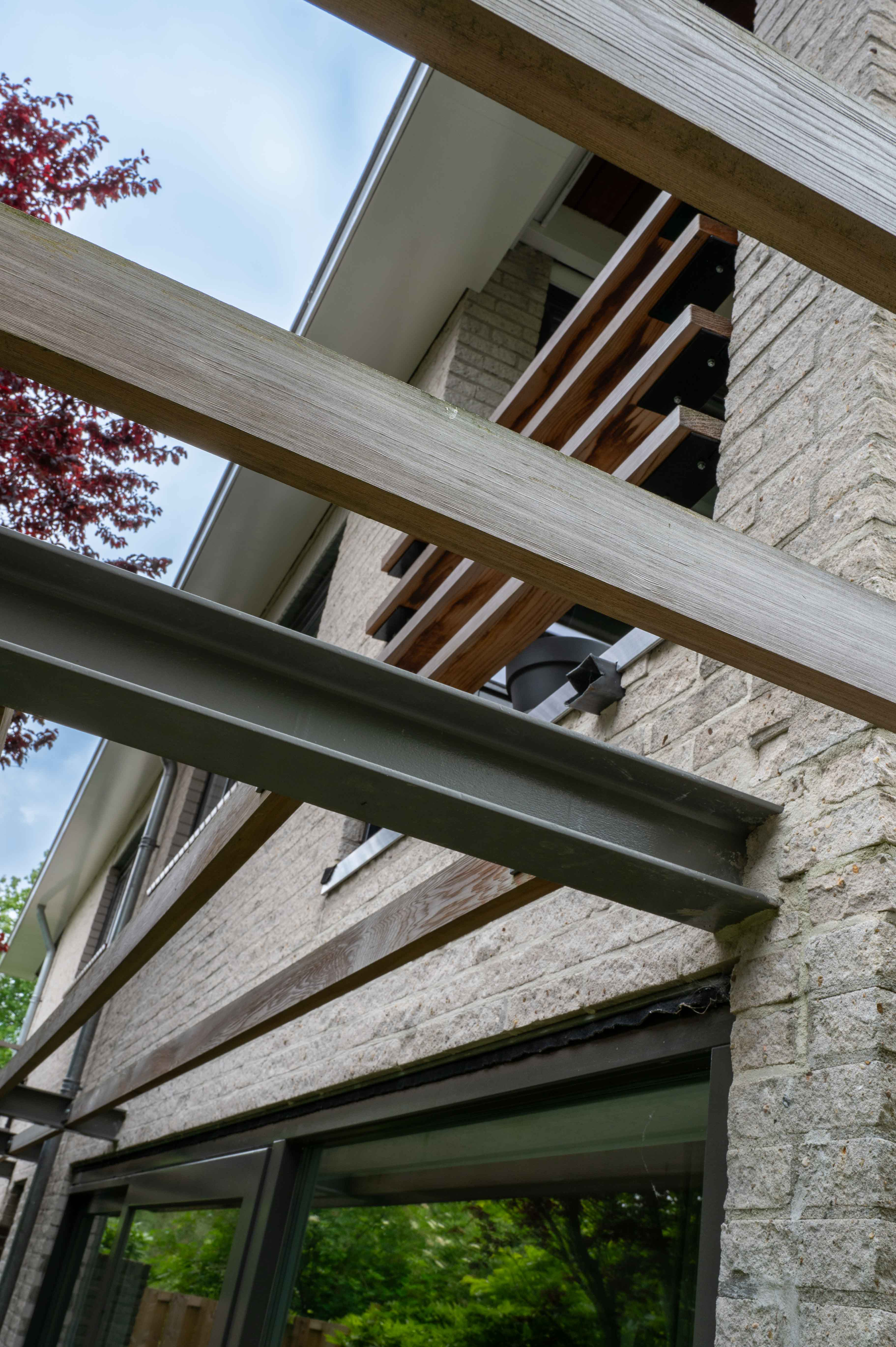 lijnenspel van balken aan een vrijstaand huis dat door bouwbedrijf w bouw gerenoveerd is