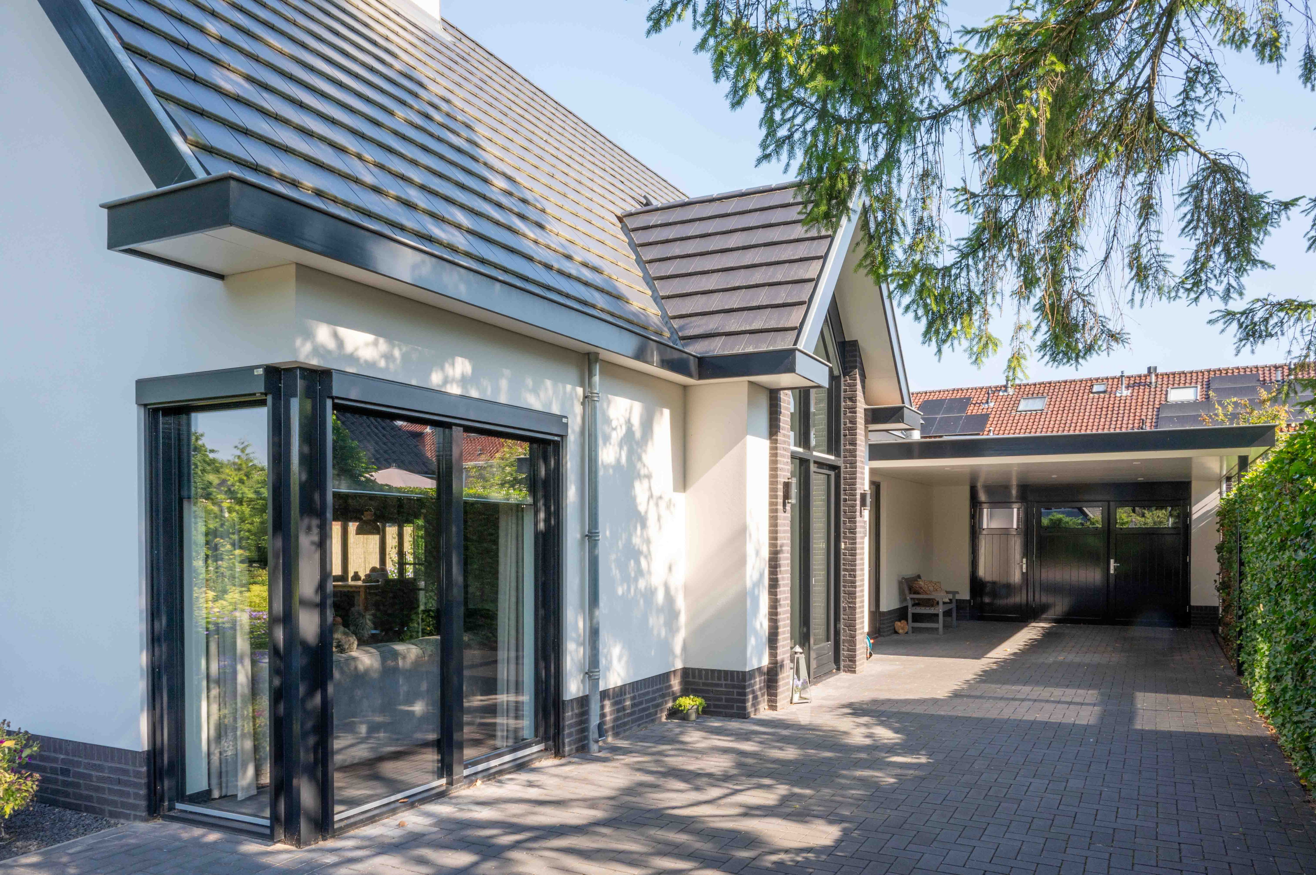 zicht op voordeur en garage wit gepleisterd huis gebouwd door bouwbedrijf w bouw