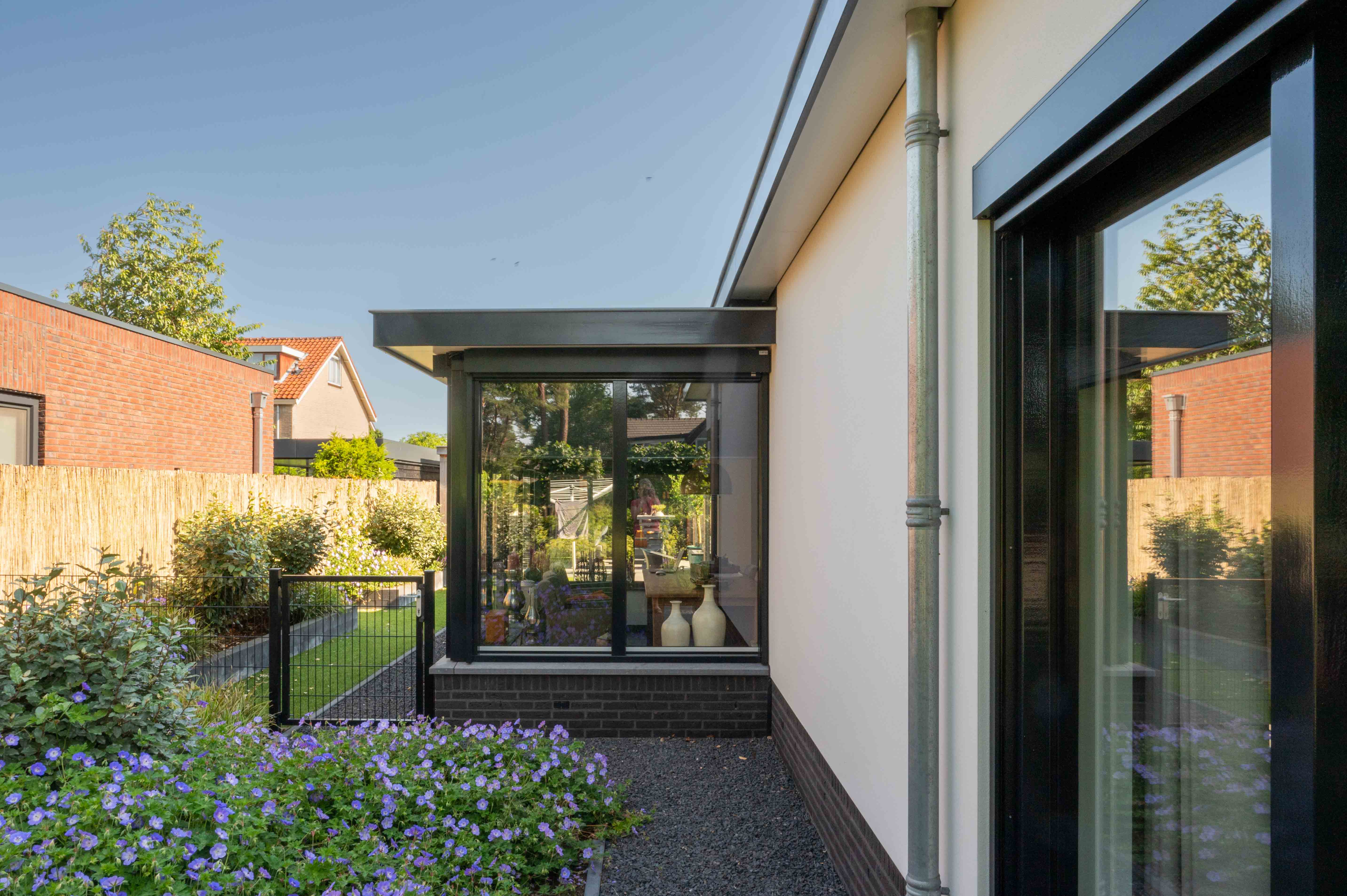 zijkant wit gepleisterd huis met serre in Putten, gebouwd door bouwbedrijf w bouw