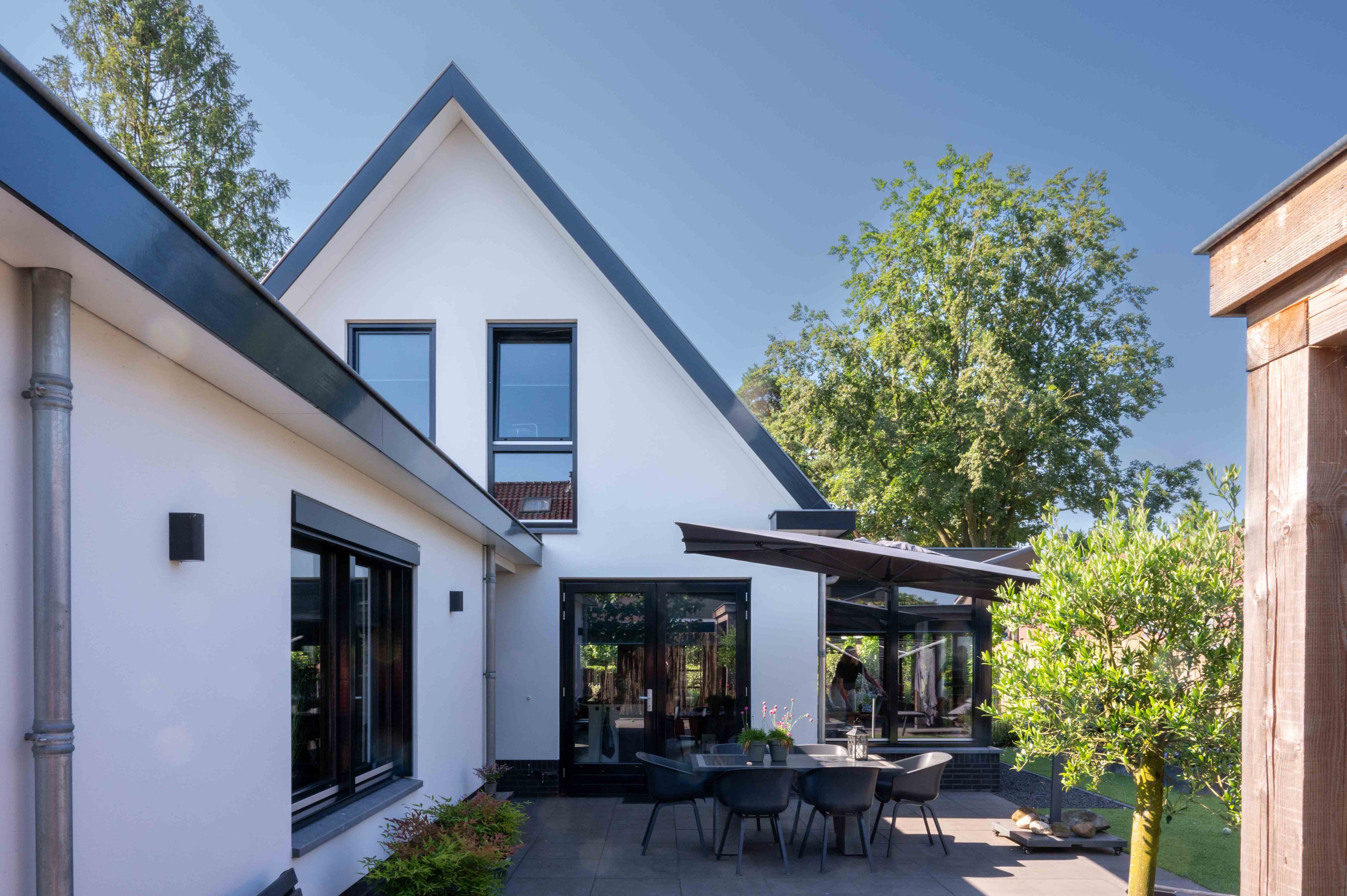 achterkant wit gepleisterd huis met serre in Putten